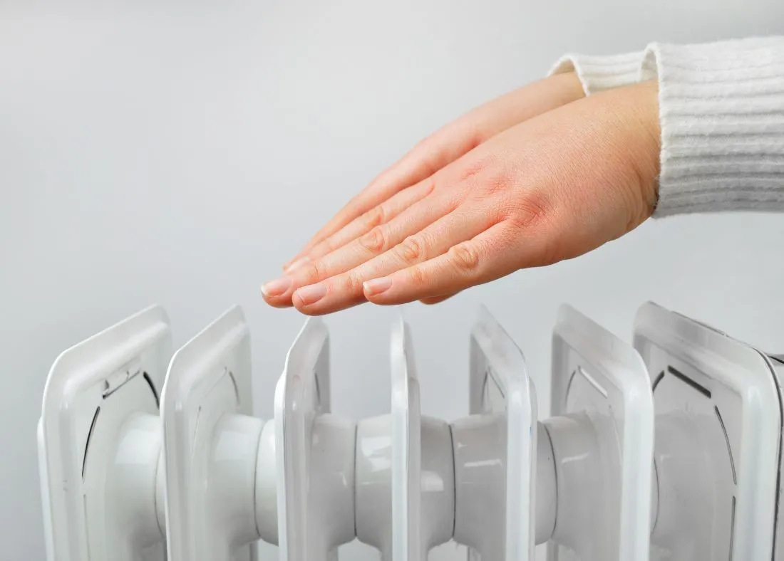 Womans hands over a radiator