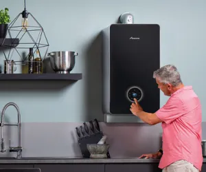 Man Pressing Buttons On Modern Black Boiler